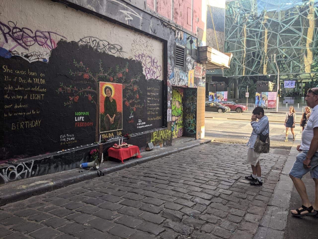 People stop to read about Yalda, current uprising and those who lost their lives recently in Iran