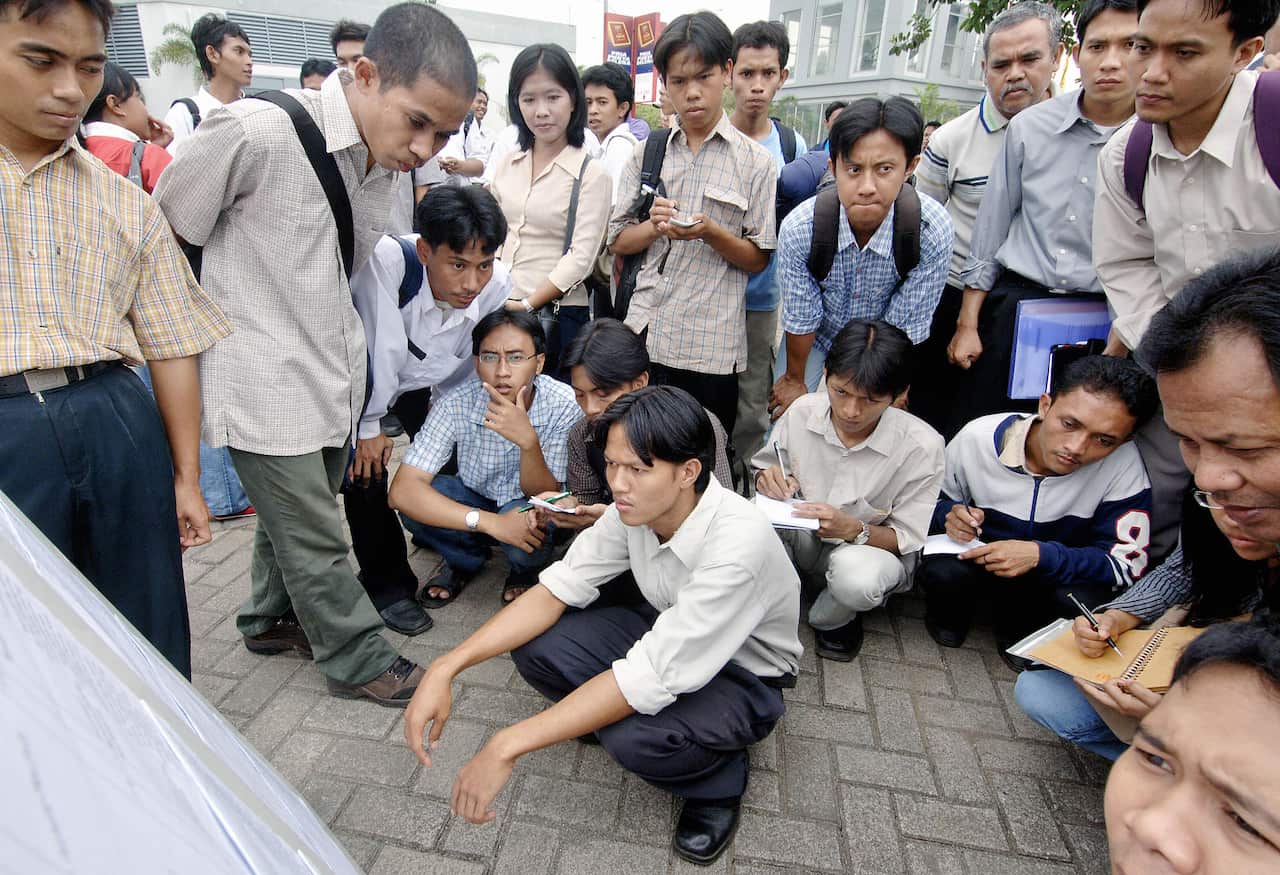 Indonesian job seekers look at the list