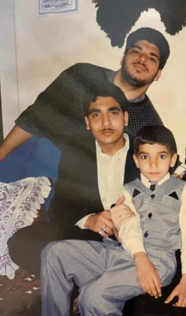 A photo of two teenage men and a young boy.