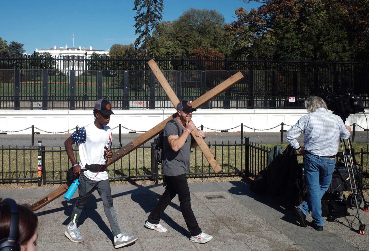 A person carries a cross outside the White House in Washington, DC
