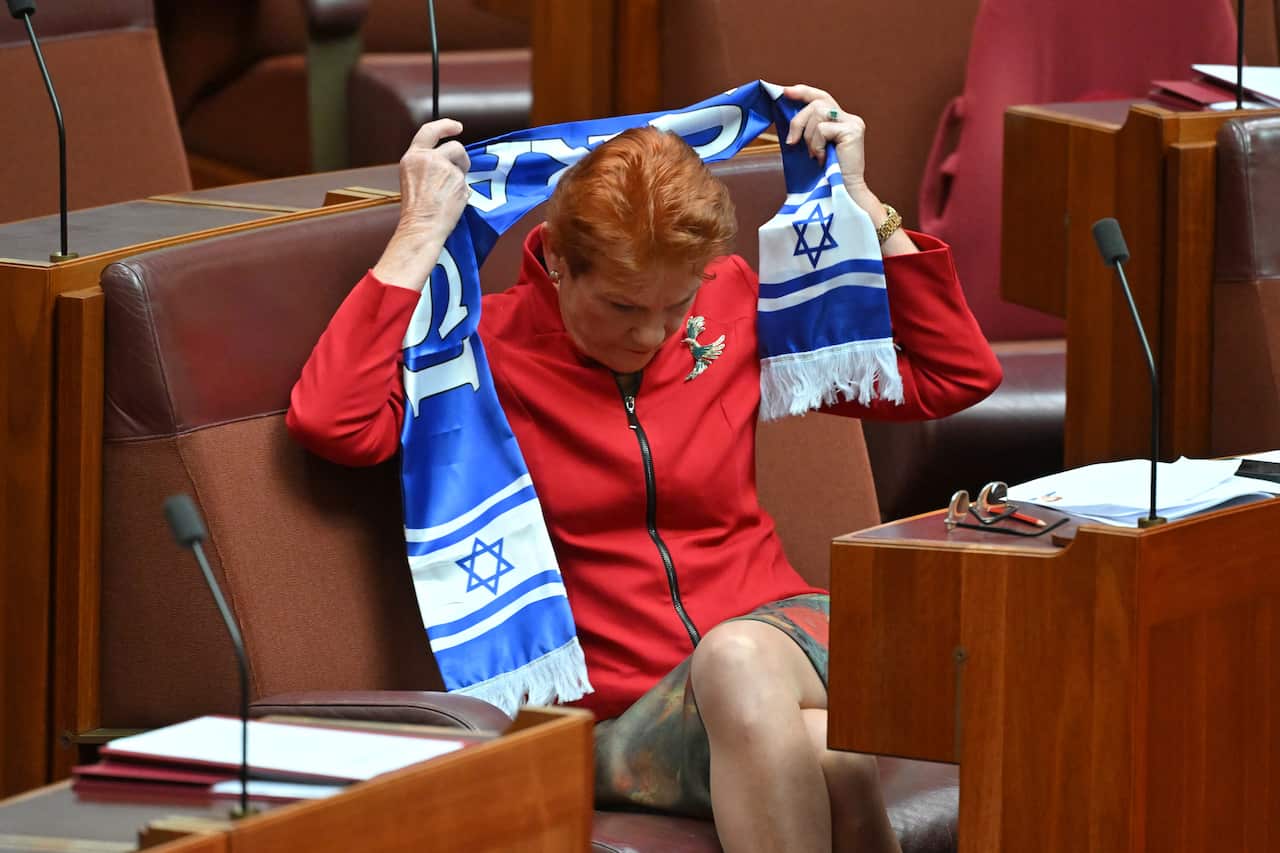 A woman taking a blue and white scarf off