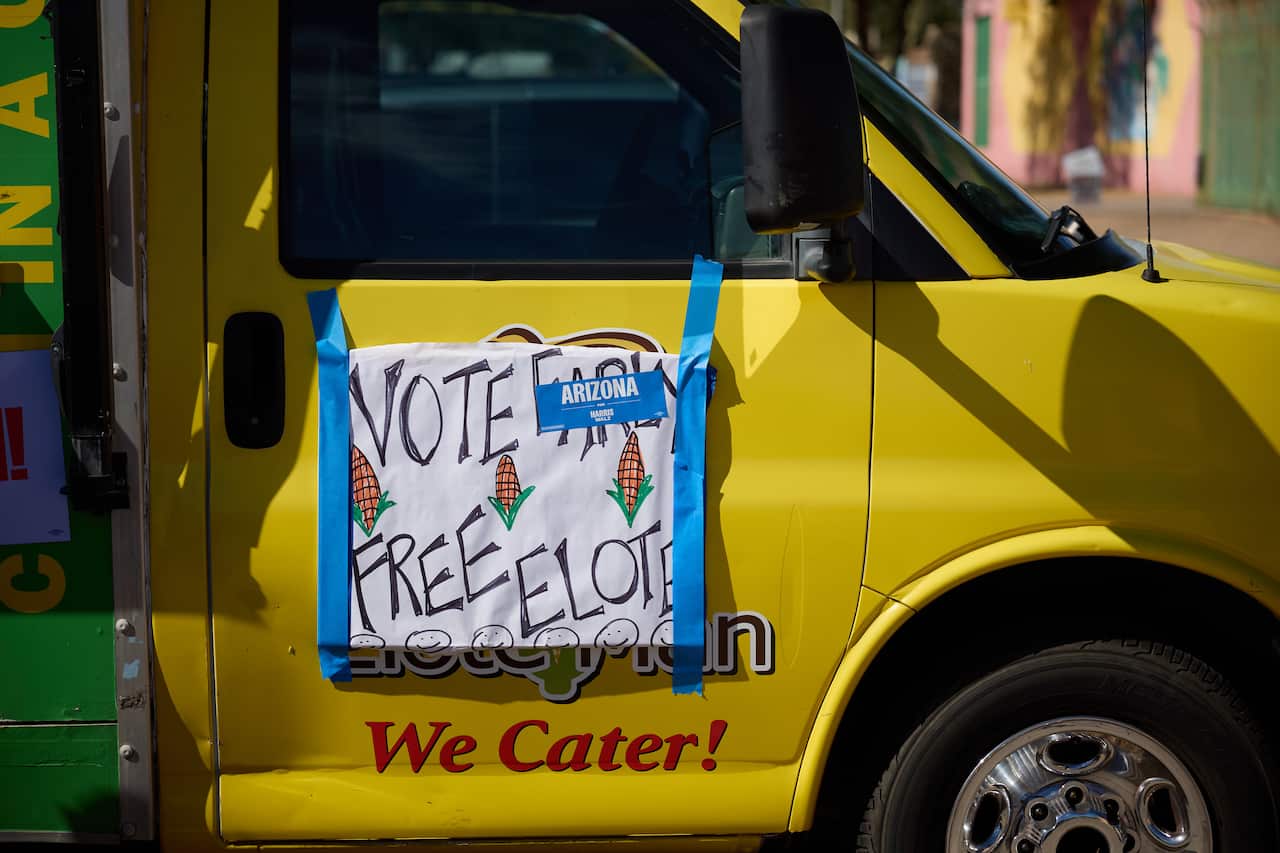 A sign taped to a car offering voters free corn.
