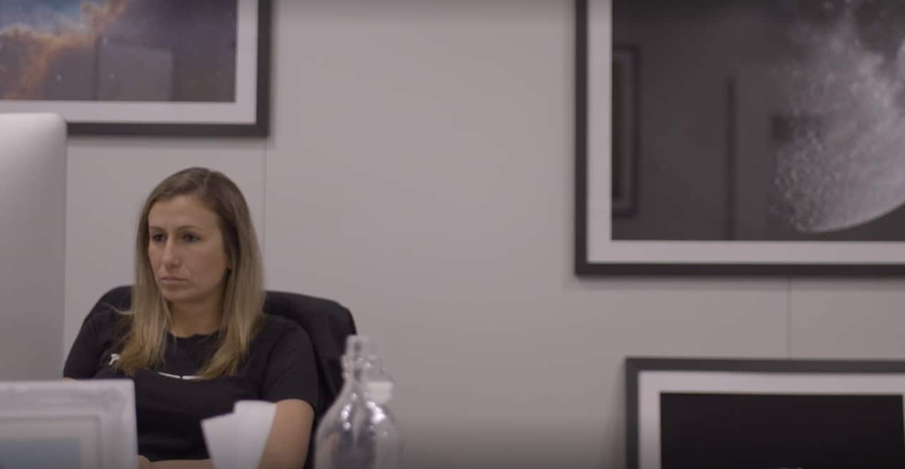 A woman types at her desk.