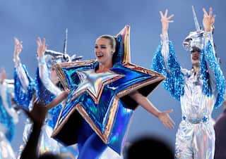 A female performer wearing a shiny blue and yellow star costume.