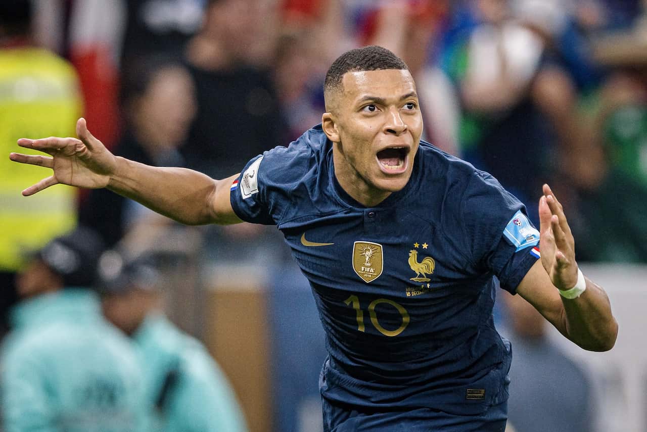 A man on a football field cheering.