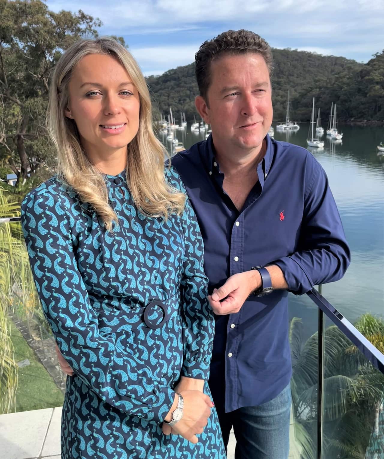 A woman and a man standing on an outdoor balcony 