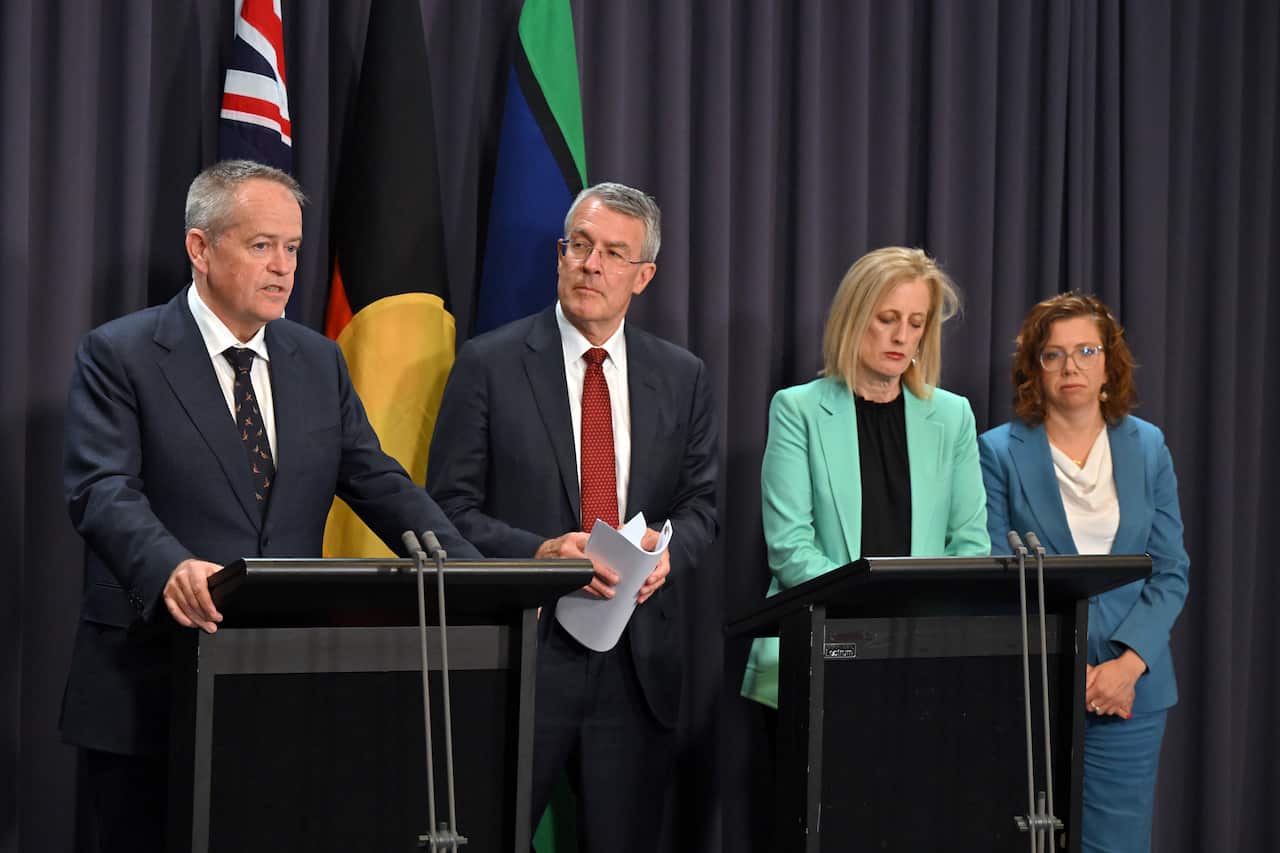 A group of politicians stand behind podiums. 