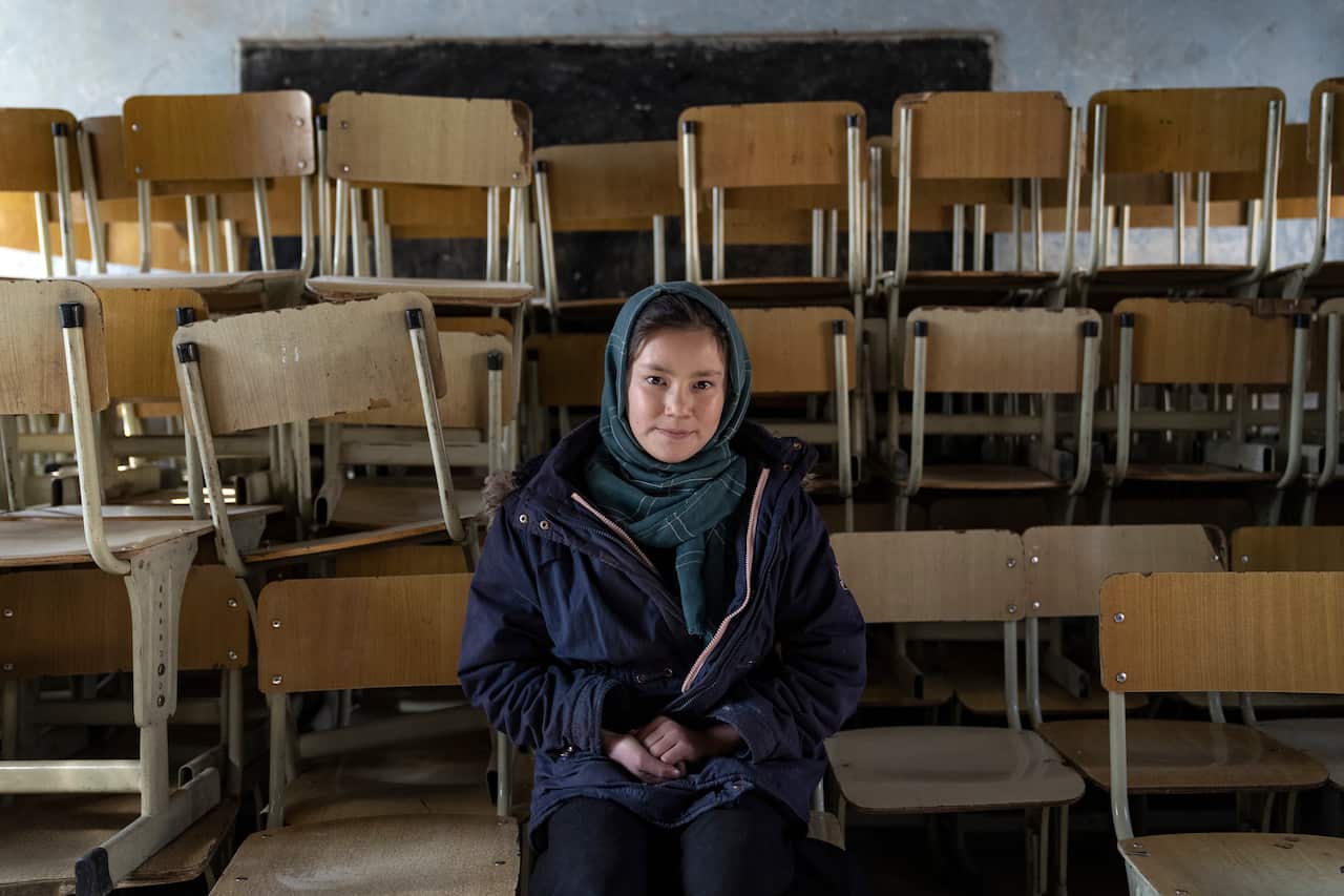 Halimah, 13-year-old schoolgirl, poses for a photo in an empty classroom in Kabul