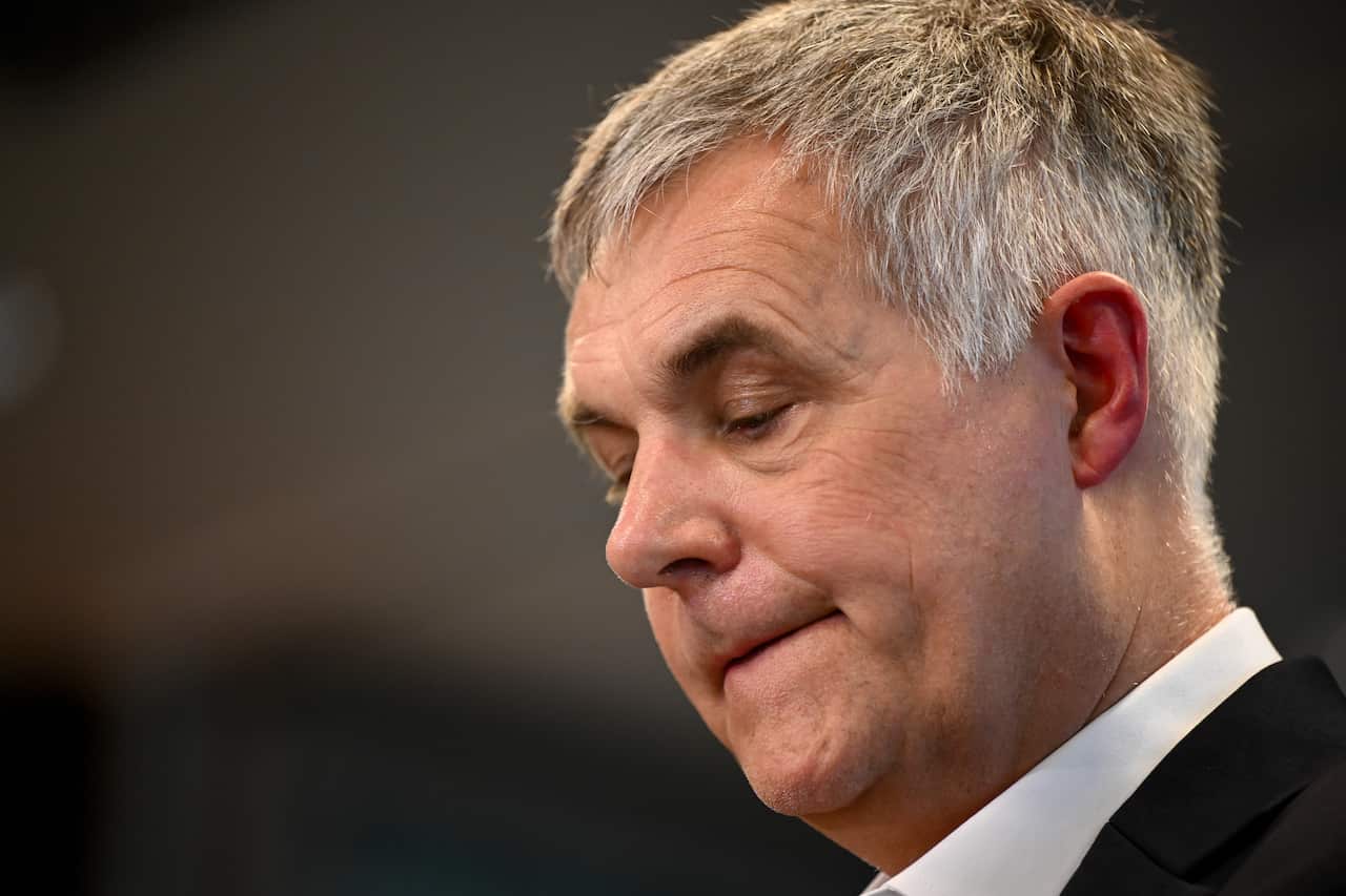 A man in a suit and tie looks down