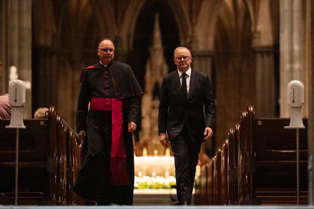 Anthony Albanese and a Catholic cardinal are walking down the aisle of a church.