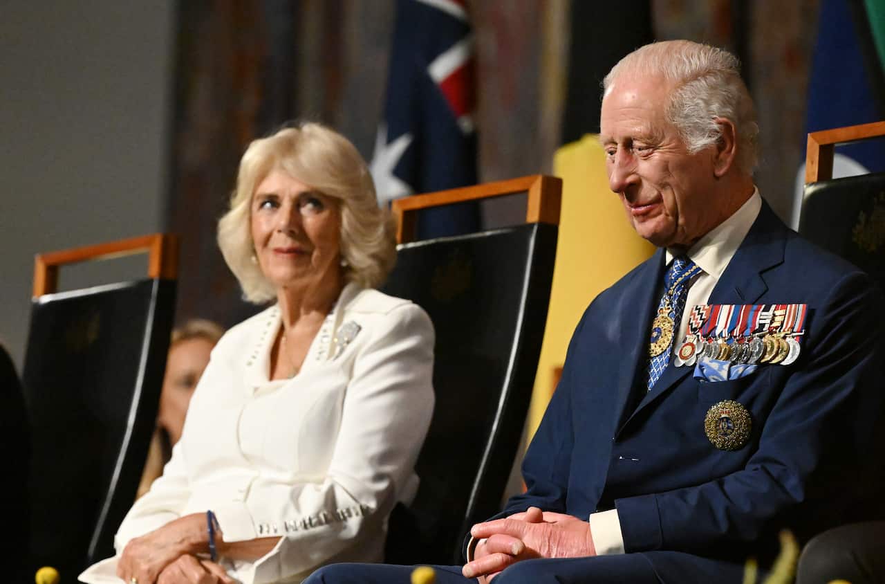King Charles III and Queen Camilla seated on stage during an event at the Australian War Memorial in Canberra.