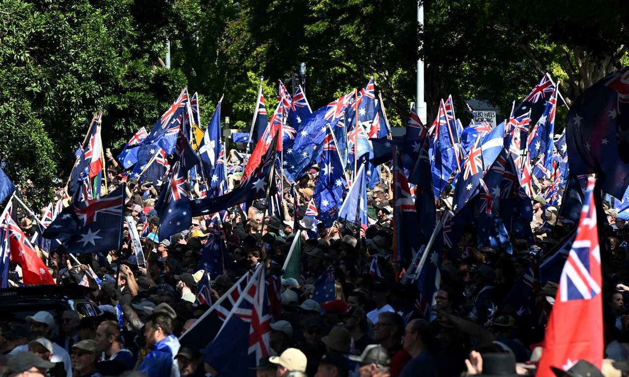 A large crowd, many of whom are waving Australian flags.