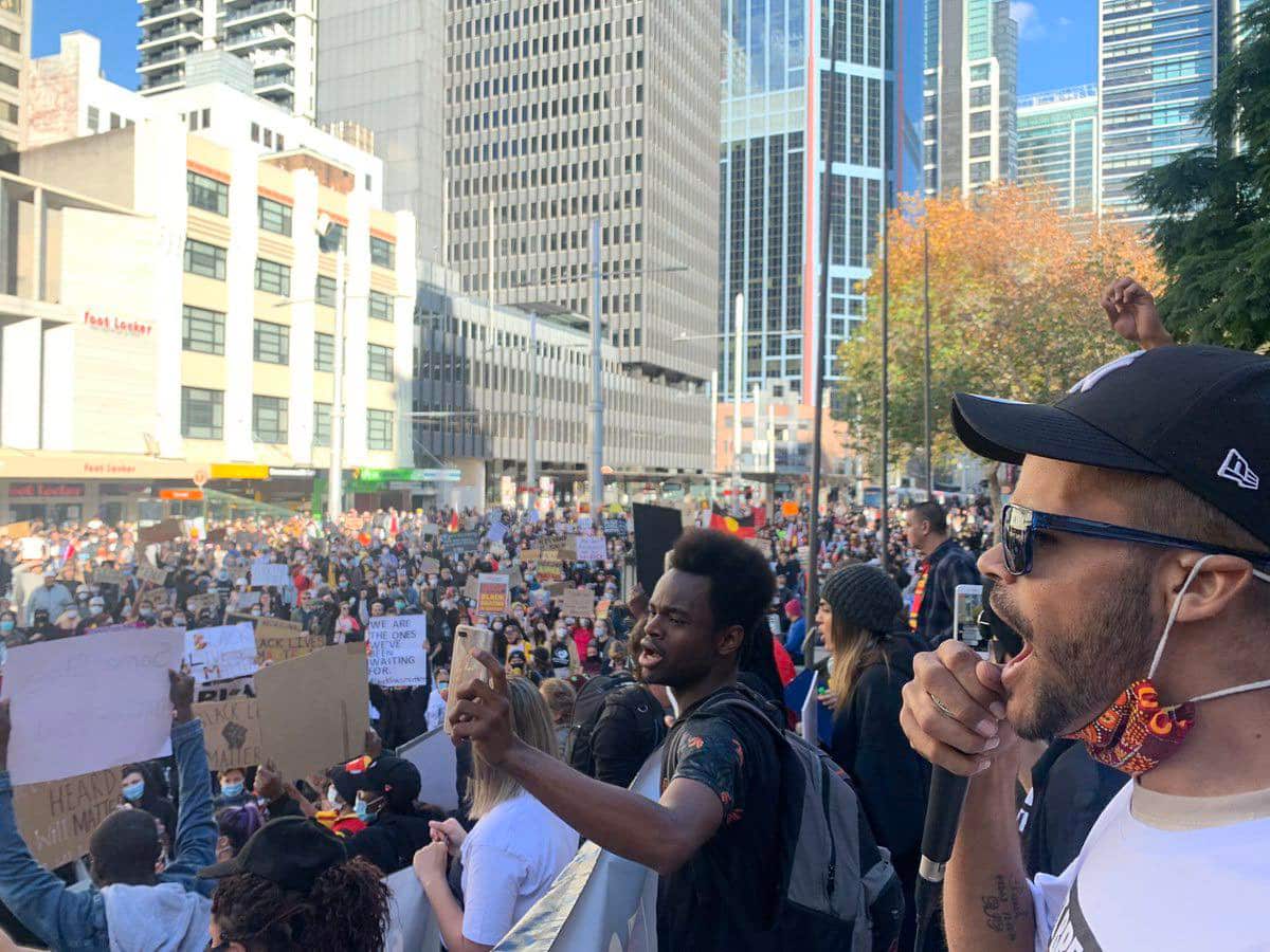 A man among a crowd calls out at a protest
