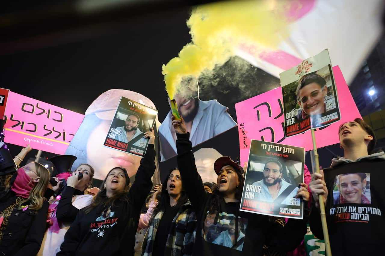 A group of protesters holding up signs in Hebrew.
