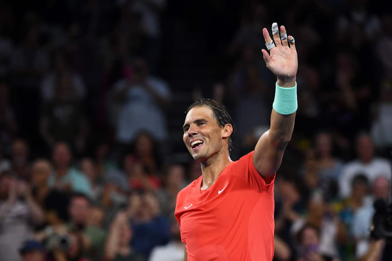 Rafael Nadal of Spain holds up his left arm and smiles as interacts with the crowd. 