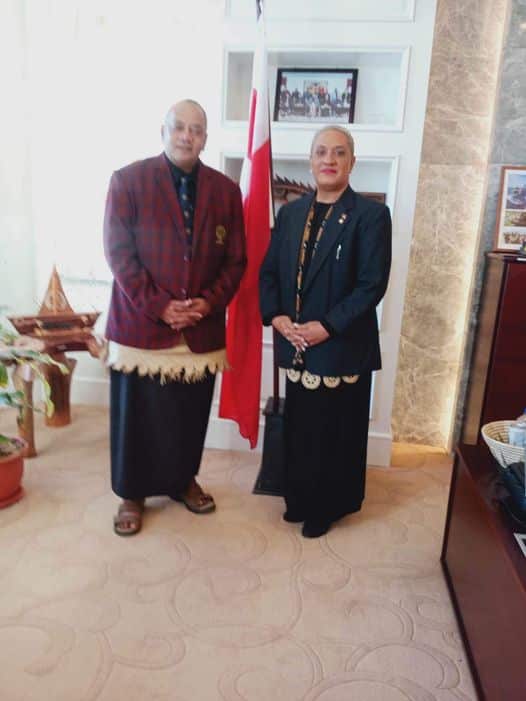 Two people in traditional Tongan dress and blazers.