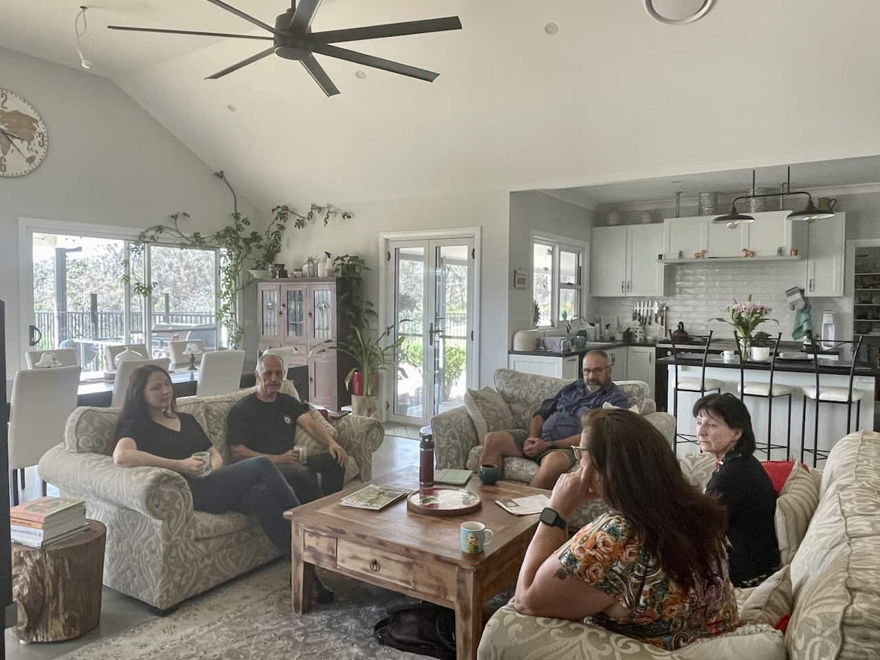 A group of people sit in a living room.