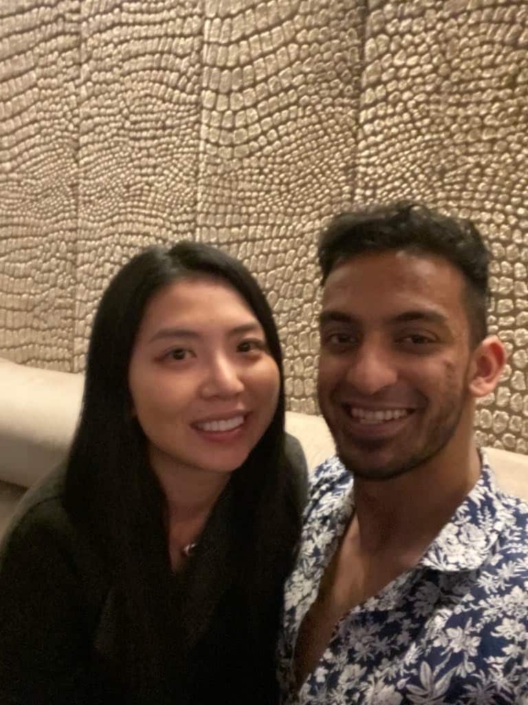 A man dressed in a blue flowery shirt poses with a woman
