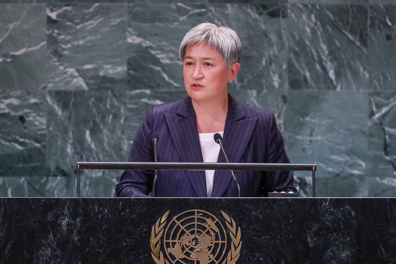 A woman stands behind a lectern.