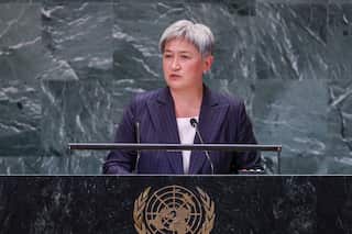 A woman stands behind a lectern.