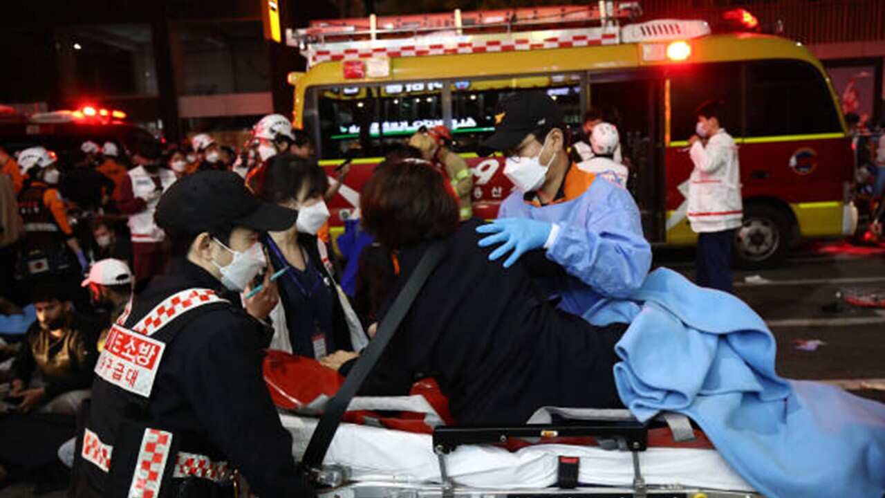 Emergency services carry injured people after a stampede on October 30, 2022 in Seoul, South Korea.jpg