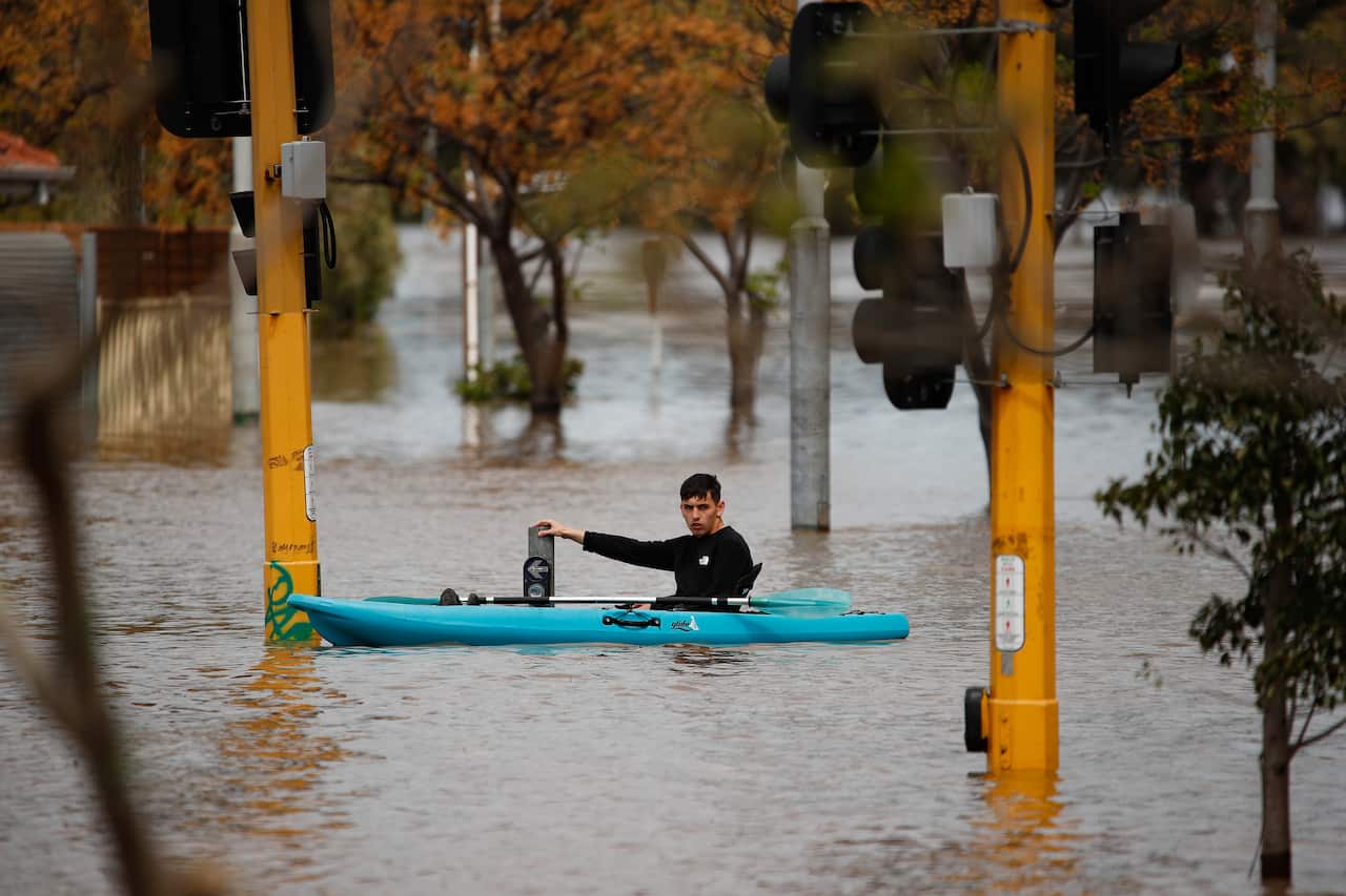 A resident navigates a flooded street in Maribyrnong, Melbourne, Friday, 14 October, 2022.
