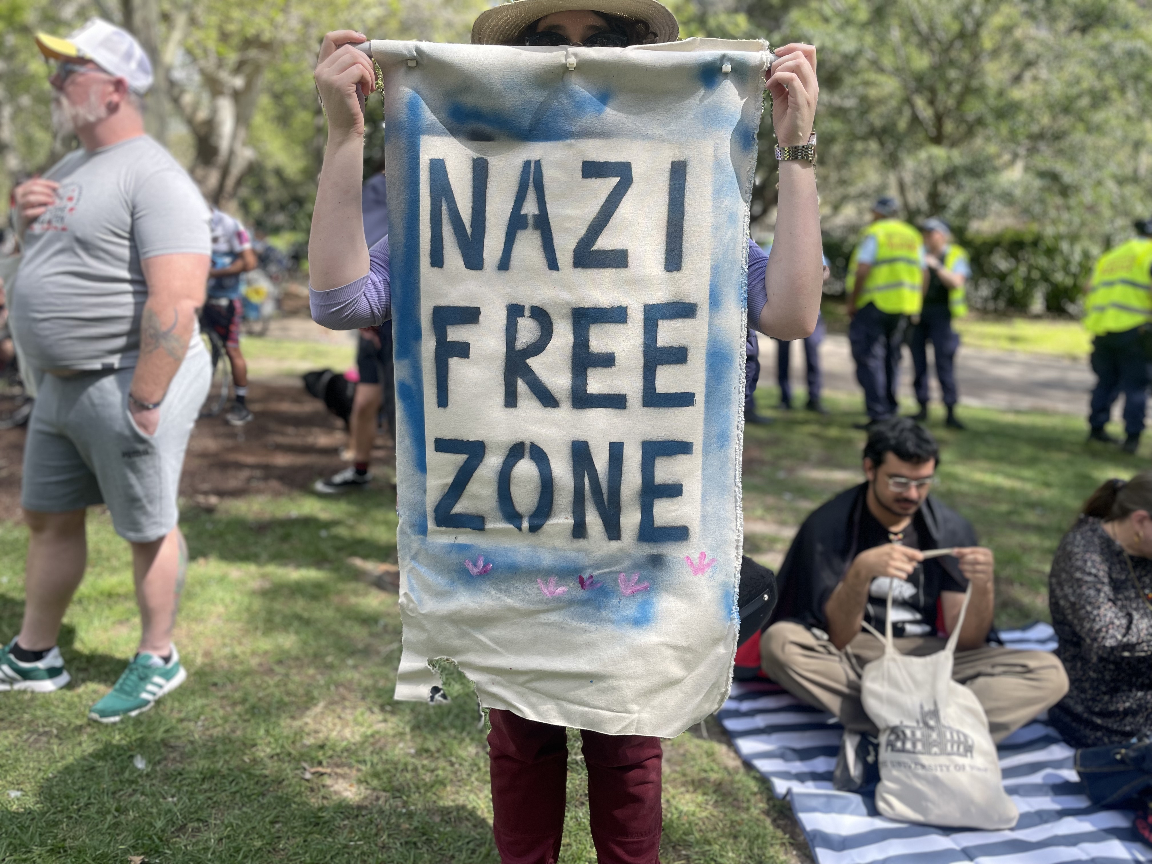 A person holding up a banner that reads 'Nazi free zone'