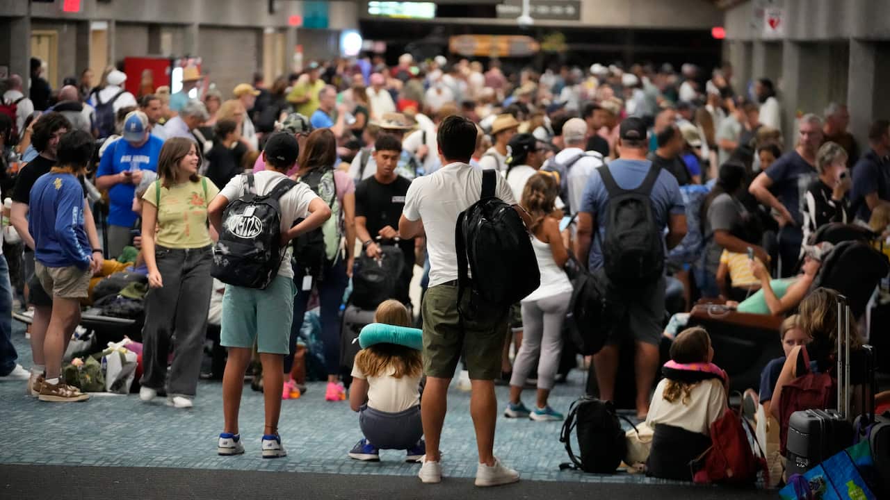 A large group of people standing in an airport.