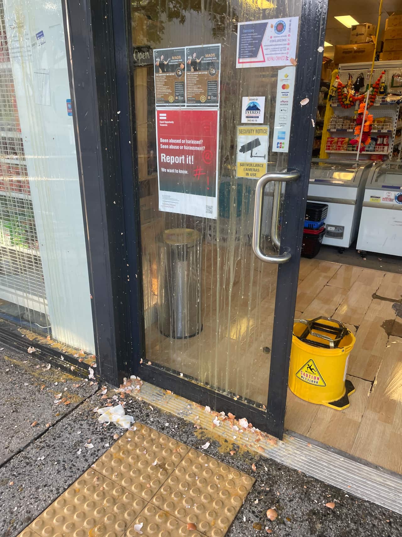Eggs were thrown at the glass door of Moonlight Supermarket, where a message to report bullying and harassment is displayed.