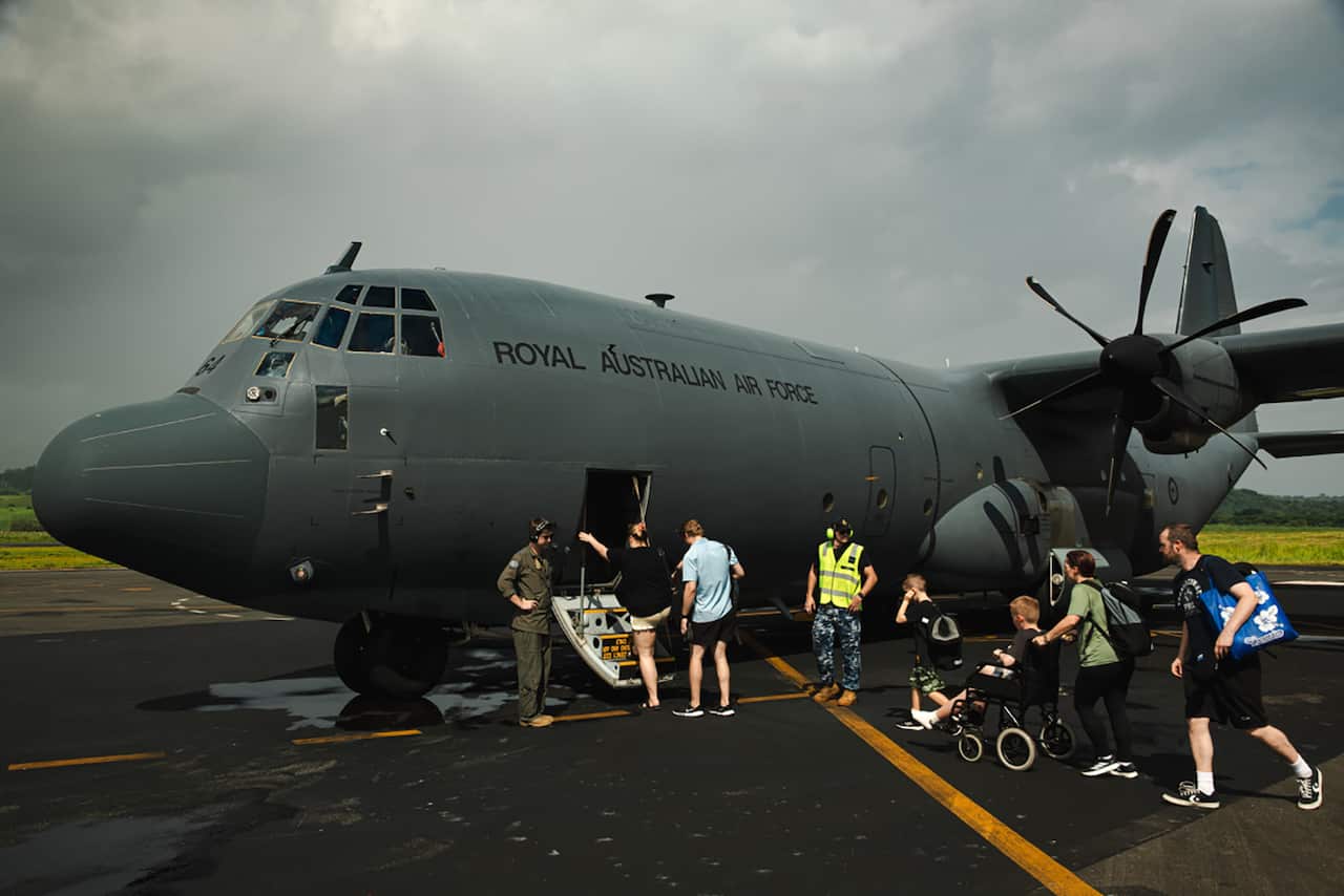 People boarding a Royal Australian Air Force C-130J Hercules flight at Bauerfield International Airport, Port Vila, Vanuatu