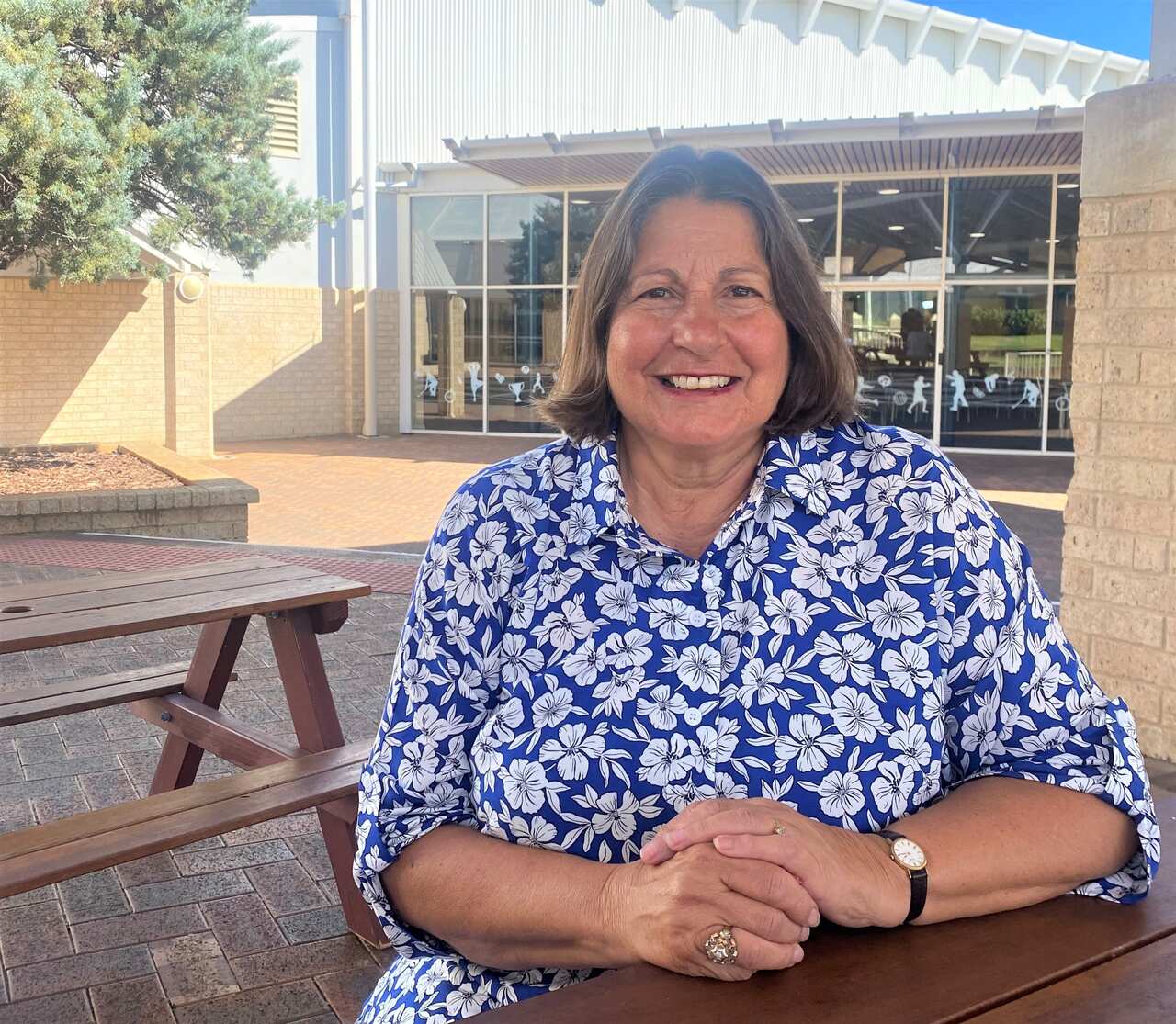 Elisa Slaven sitting at a wooden outdoor table