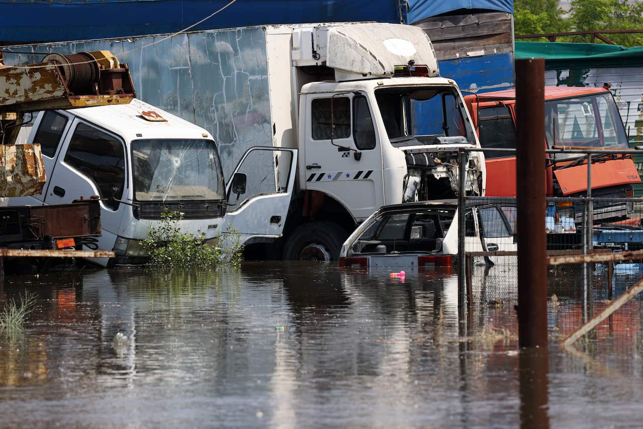 Abandoned trucks and cars partially submerged under floodwaters