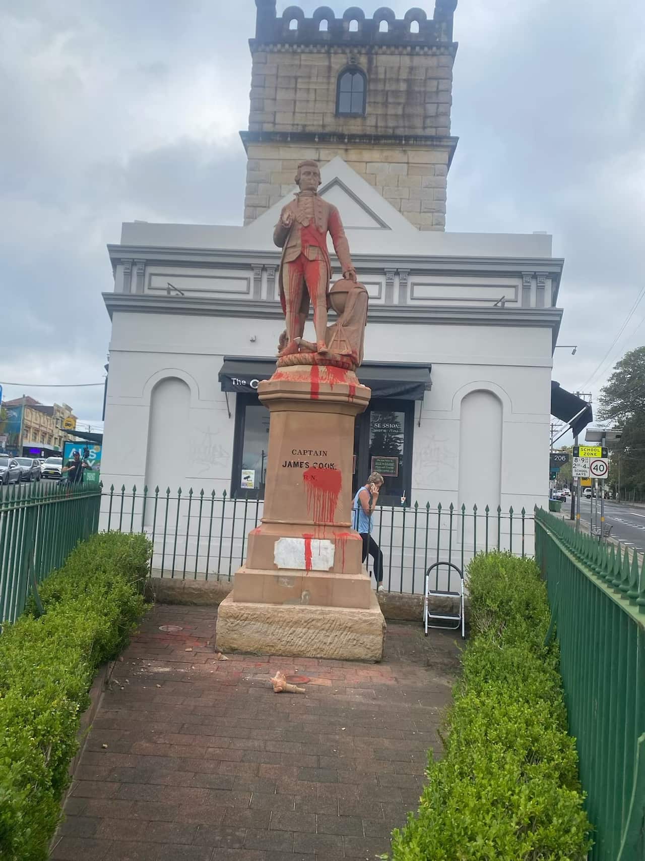 A statue of Captain Cook splashed with red paint.