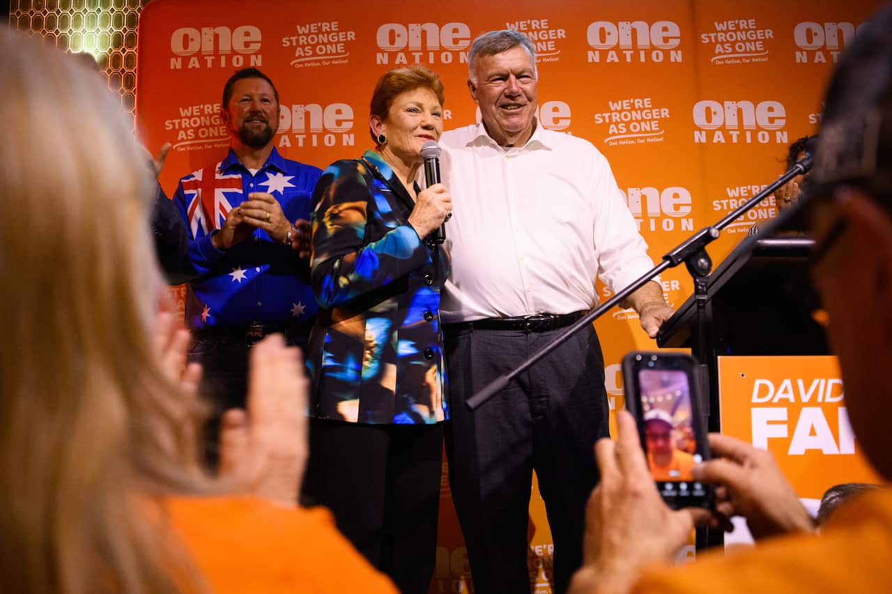 Pauline Hanson stands next to David Farley against an orange One Nation backdrop.