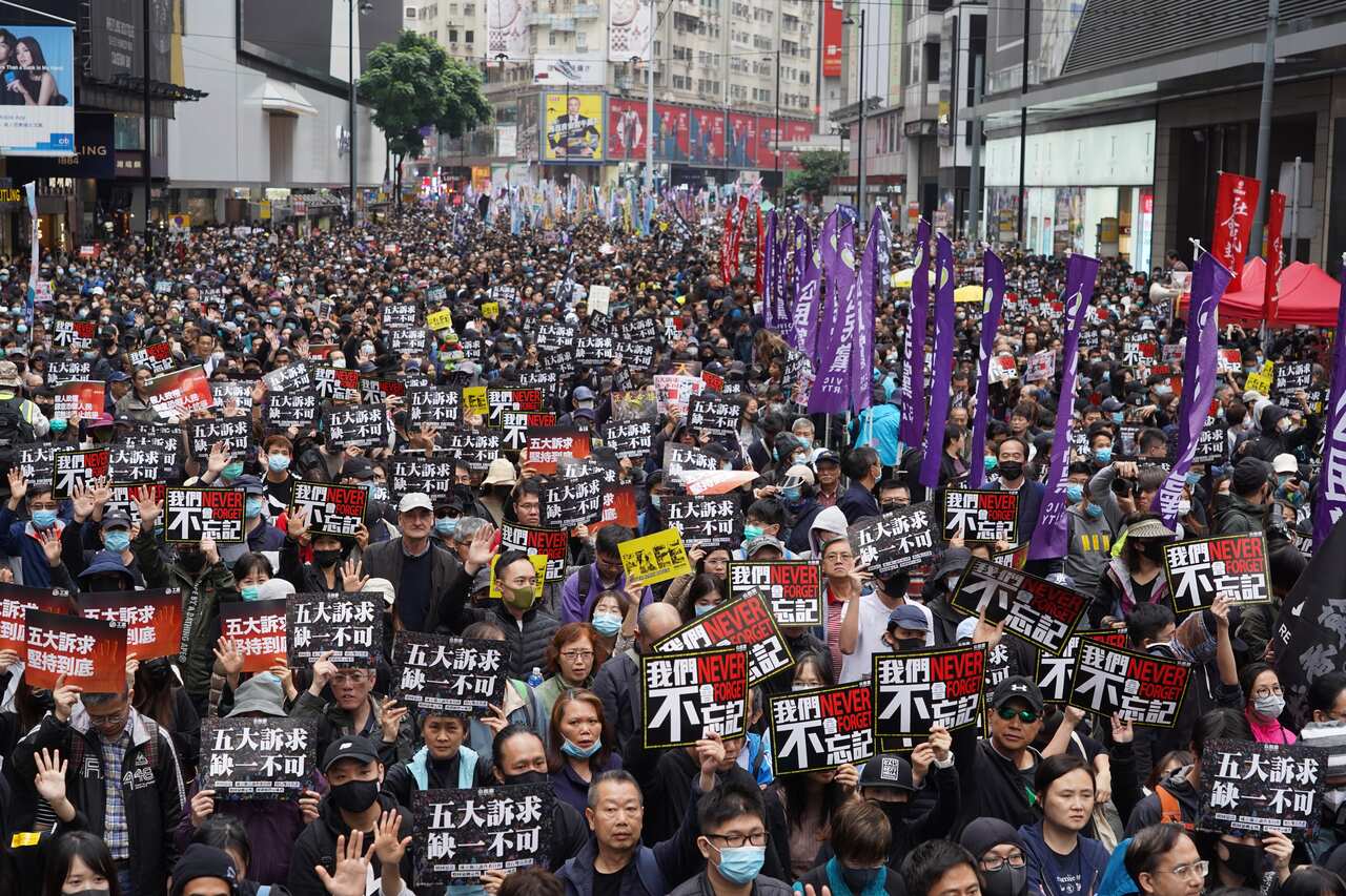 A large crowd of people holding signs in the street