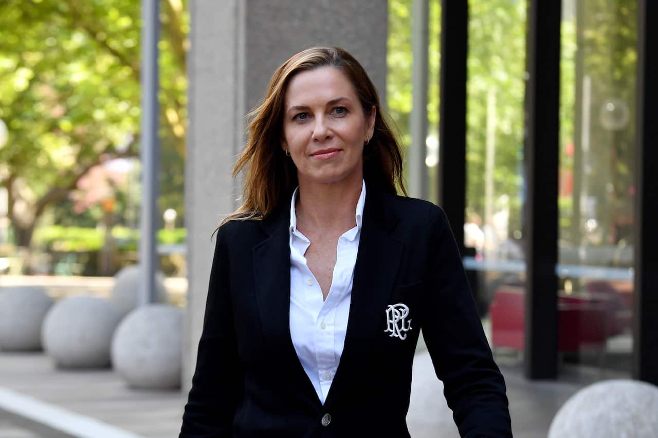 A woman wearing formal attire walking outside.