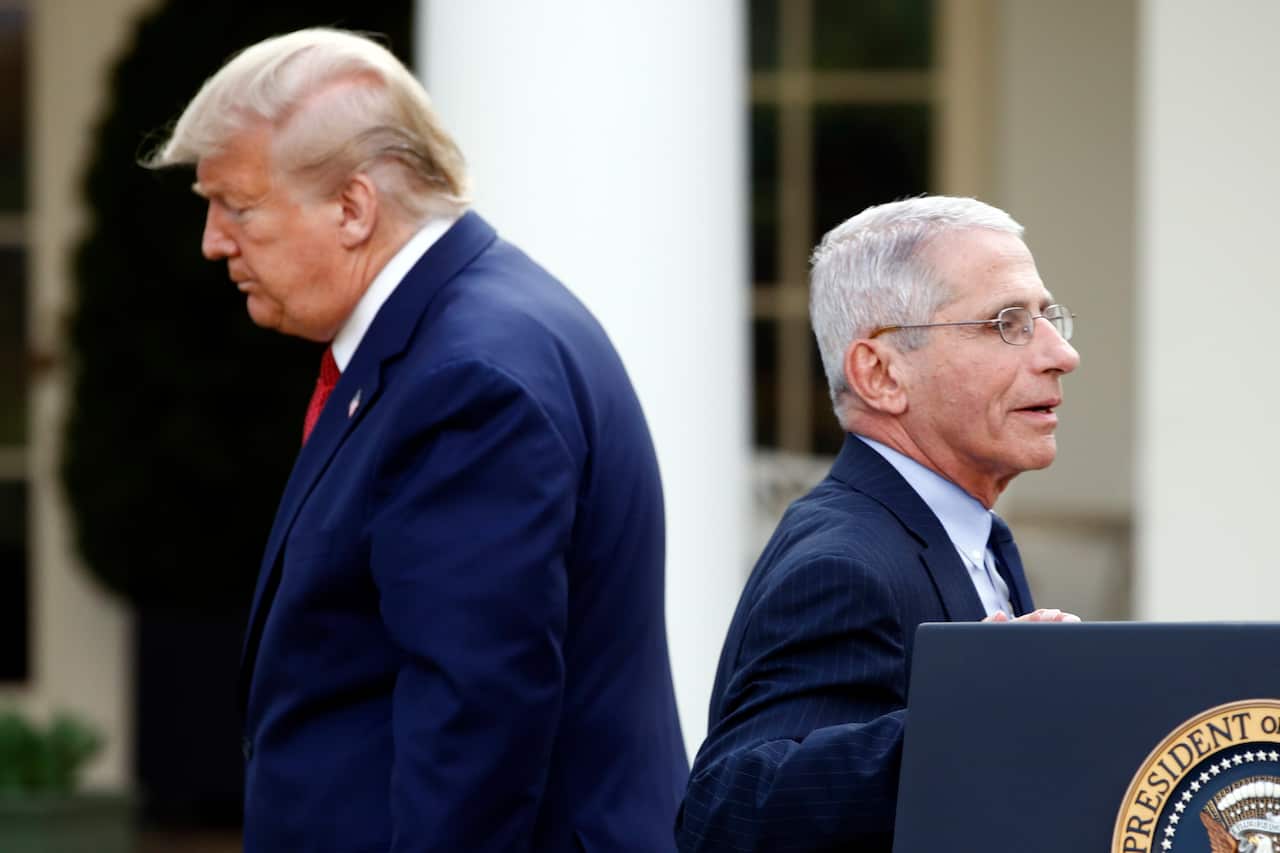 Donald Trump and Anthony Fauci walking past each other.
