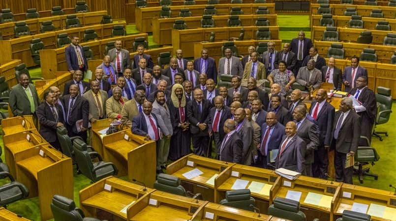 A large group of men in suits, and one woman, in Papua New Guinea parliament building 