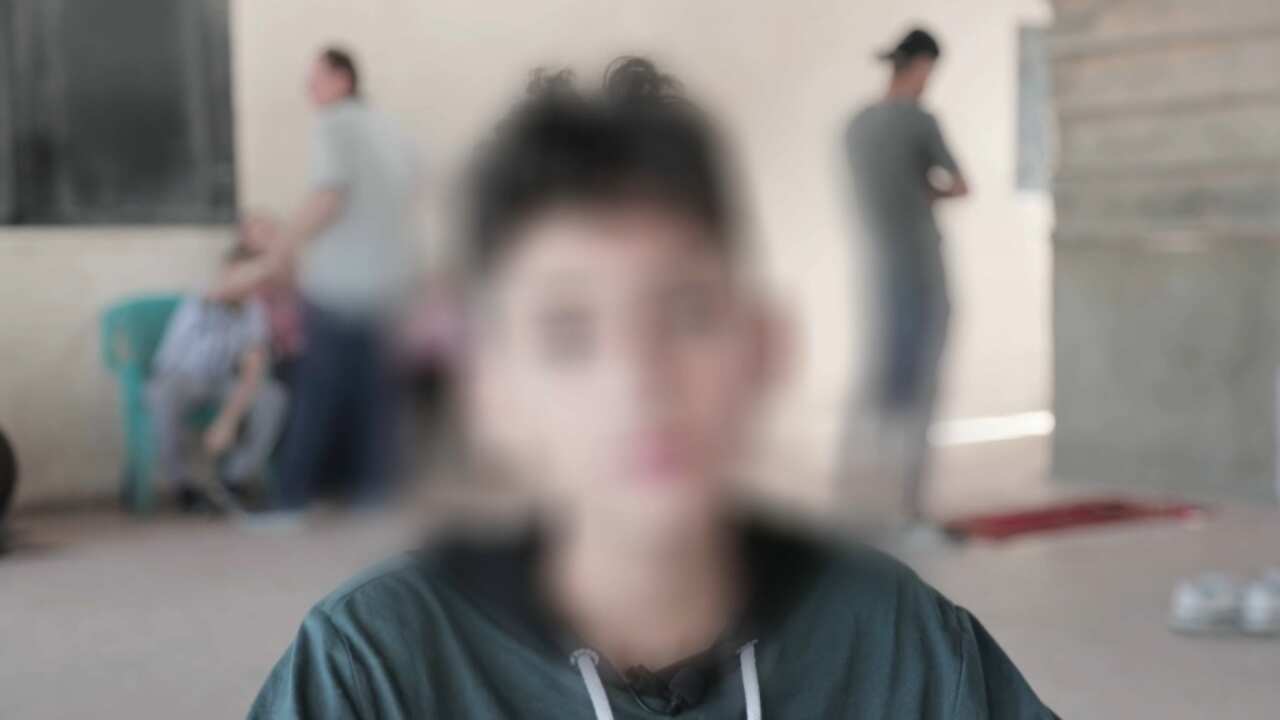 A young boy with a black hoodie.