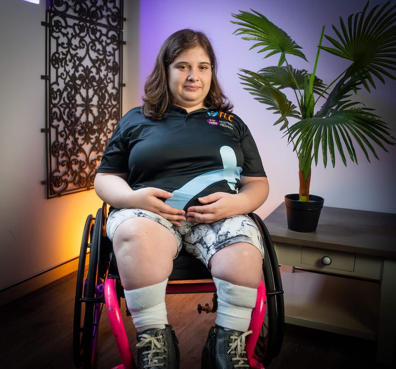 Rita Nichola sitting on a wheelchair at an office.