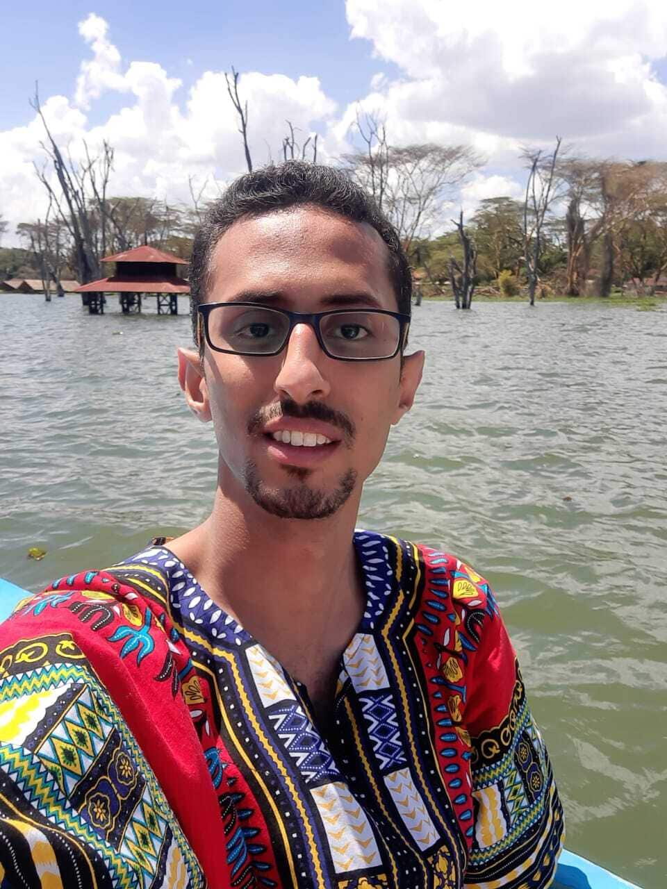Abdo Gamal Taher wearing a brightly-coloured shirt and sitting in a boat