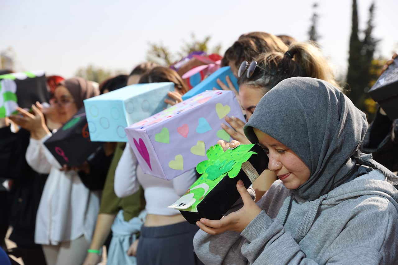 People observe a solar eclipse using a "pinhole projector" technique.