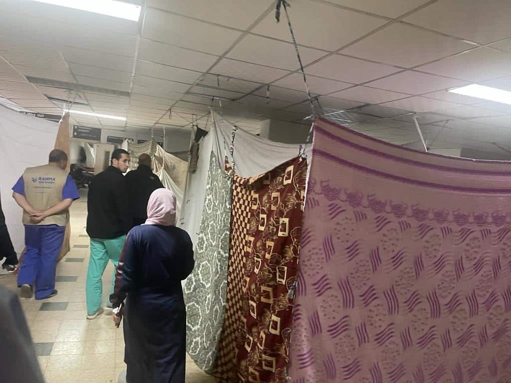 The makeshift shelters made by refugees in hospital hallways are seen, they are blocked off by blankets strung up on string.