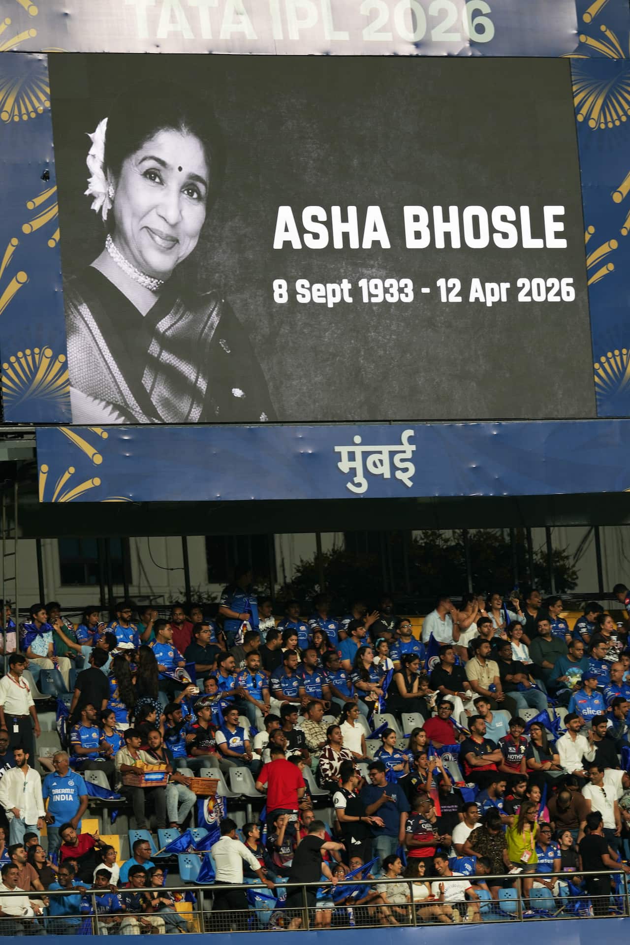 A tribute to legendary Indian singer Asha Bhosle reflects on the giant screen at a cricket game.