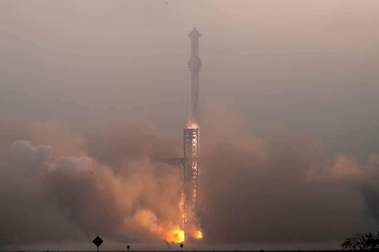 A rocket is surrounded by flame and smoke as it begins to launch