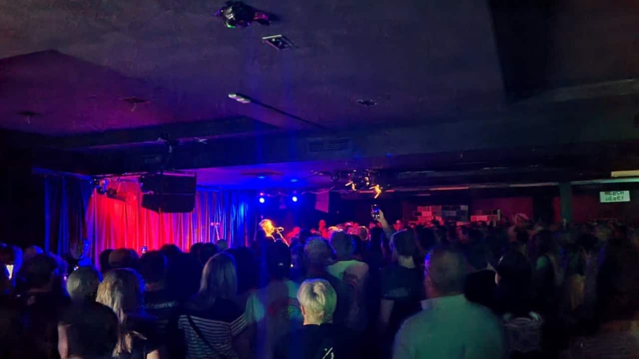 a musician singing on stage in a crowded club