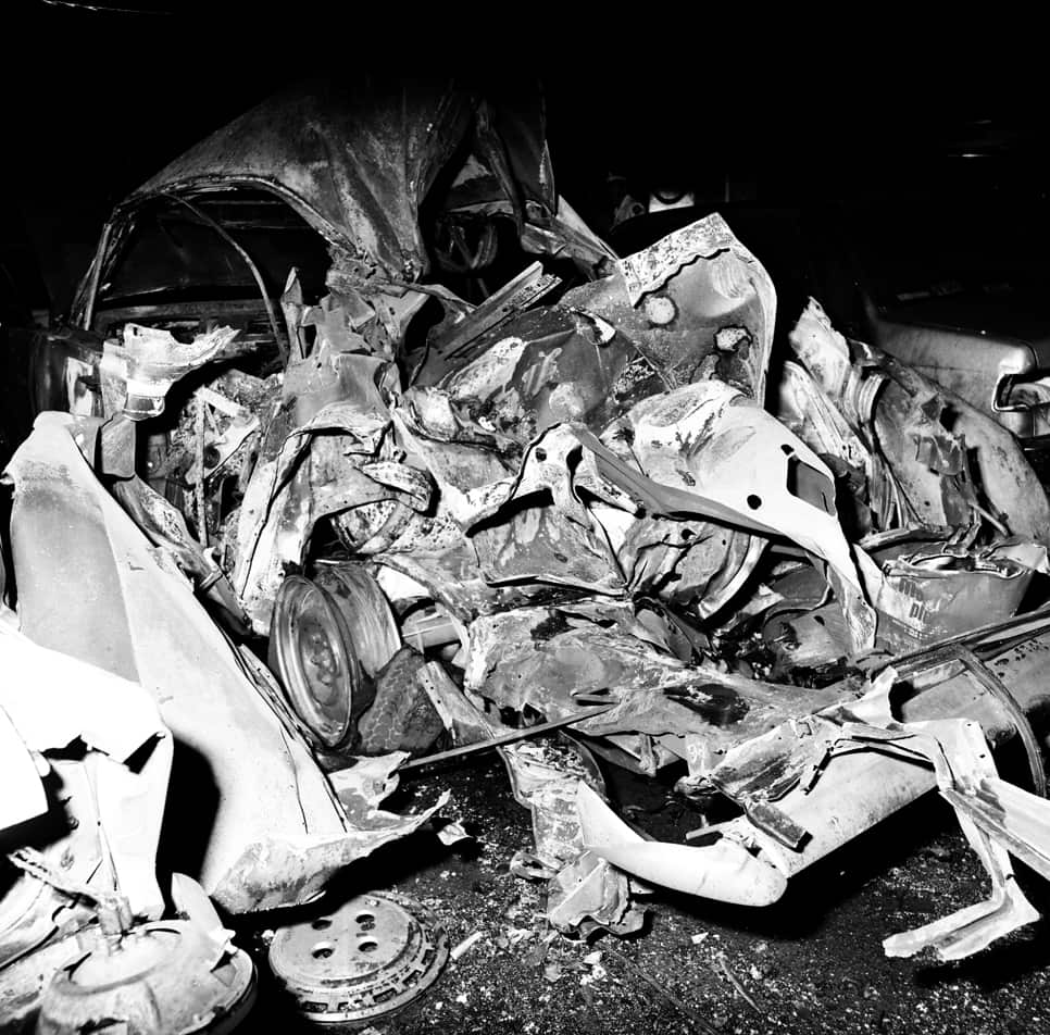 A black and white photo of a car that has been destroyed.