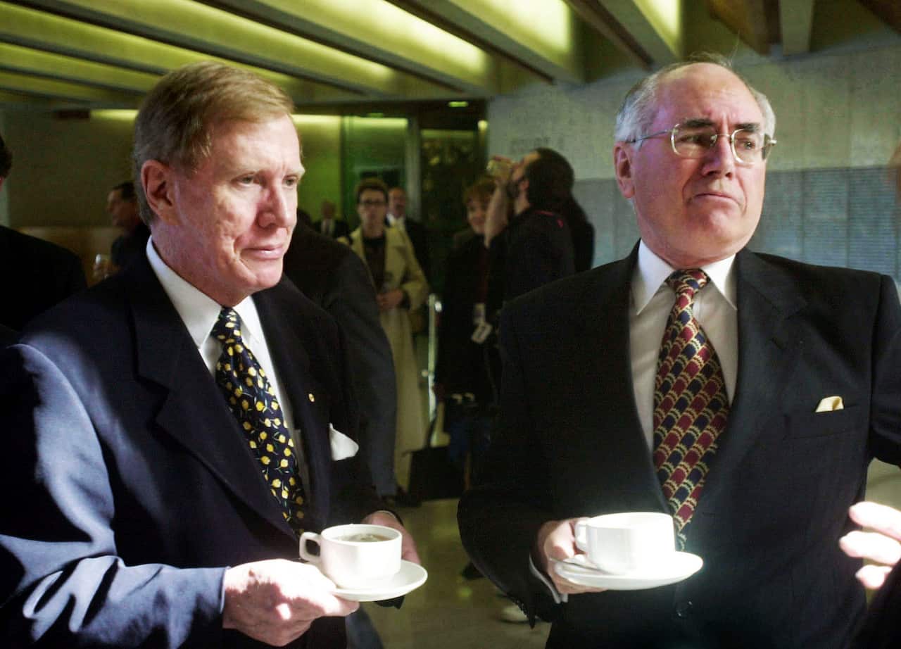 Two men in suits holding tea cups