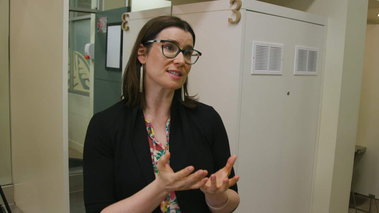 A bespectacled woman talking 