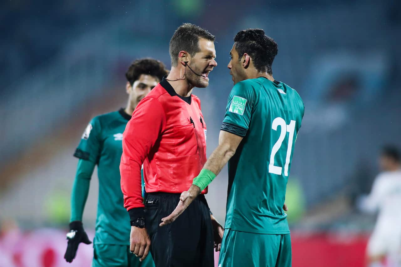 A referee looking animated while a player reacts